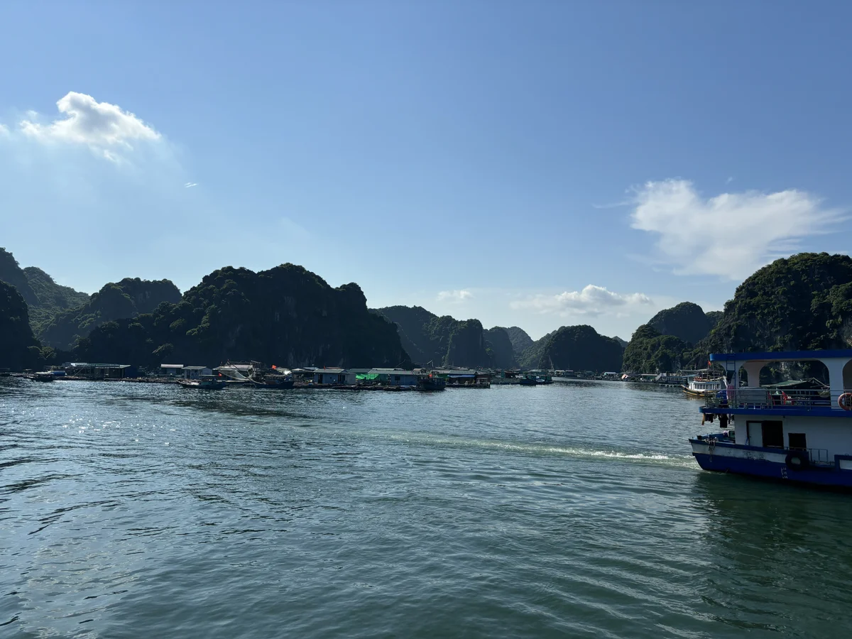 Boats on the water with islets rising out of the water on the horizon