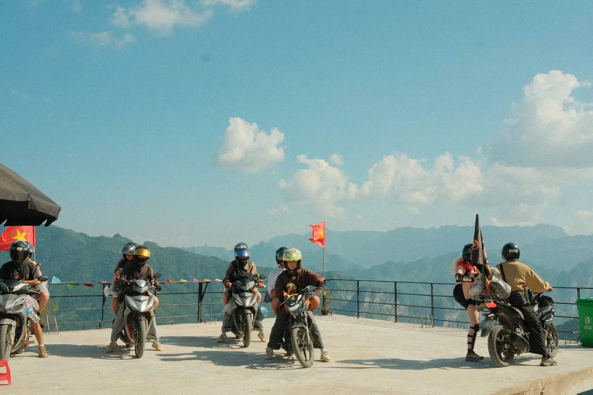 A group of people on bikes at a viewpoint overlooking mountains