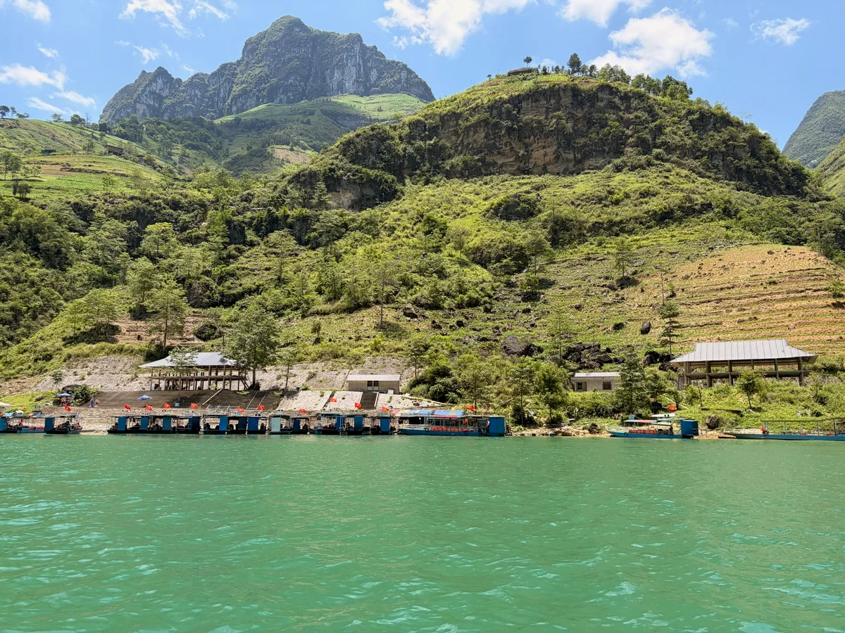 An emerald-green river winds between green mountains