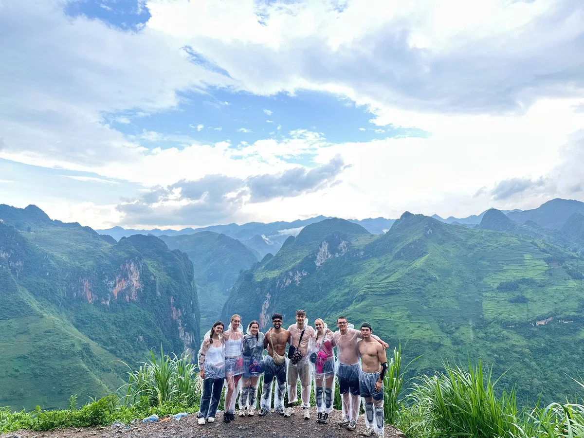 A group of people stand with a canyon behind them