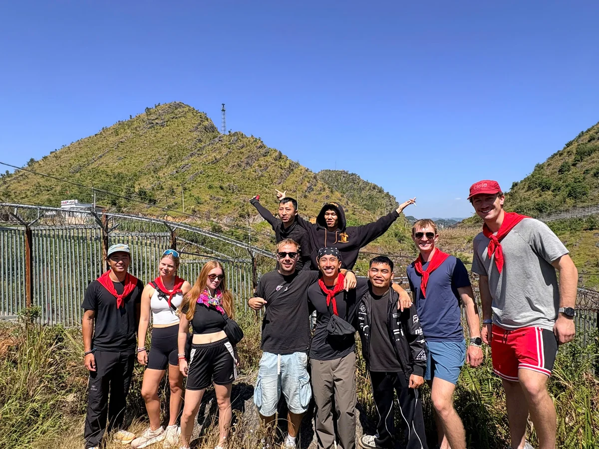 A group of people pose in front of a mountain