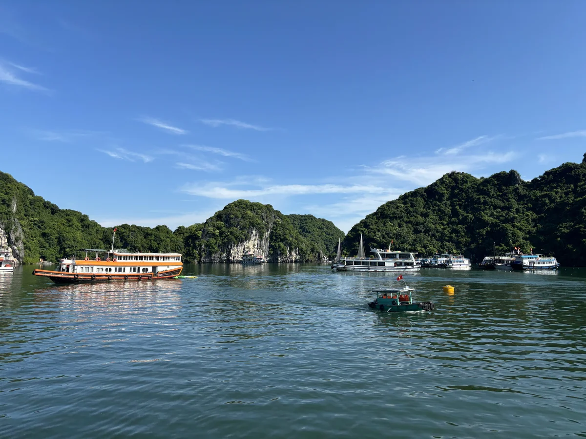 Boats on an ocean with islets rising out of the water