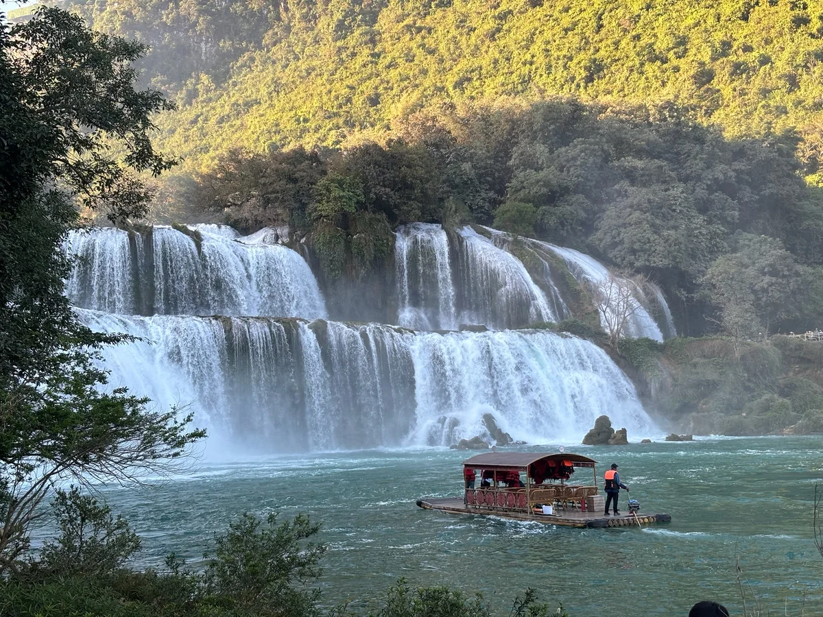Roaring waterfall with a boat on the water