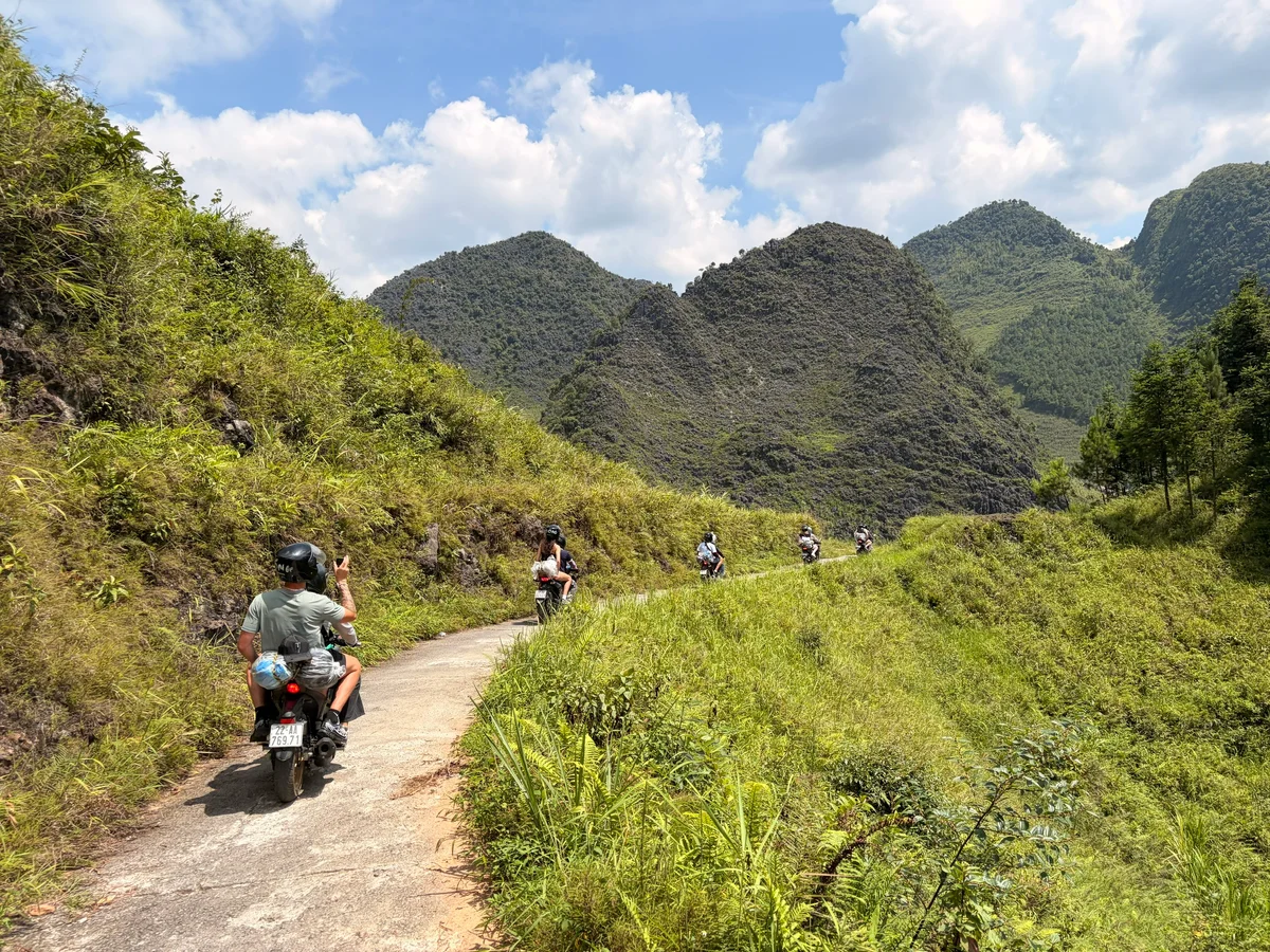 Motorbikes driving on a small road into mountain scenery