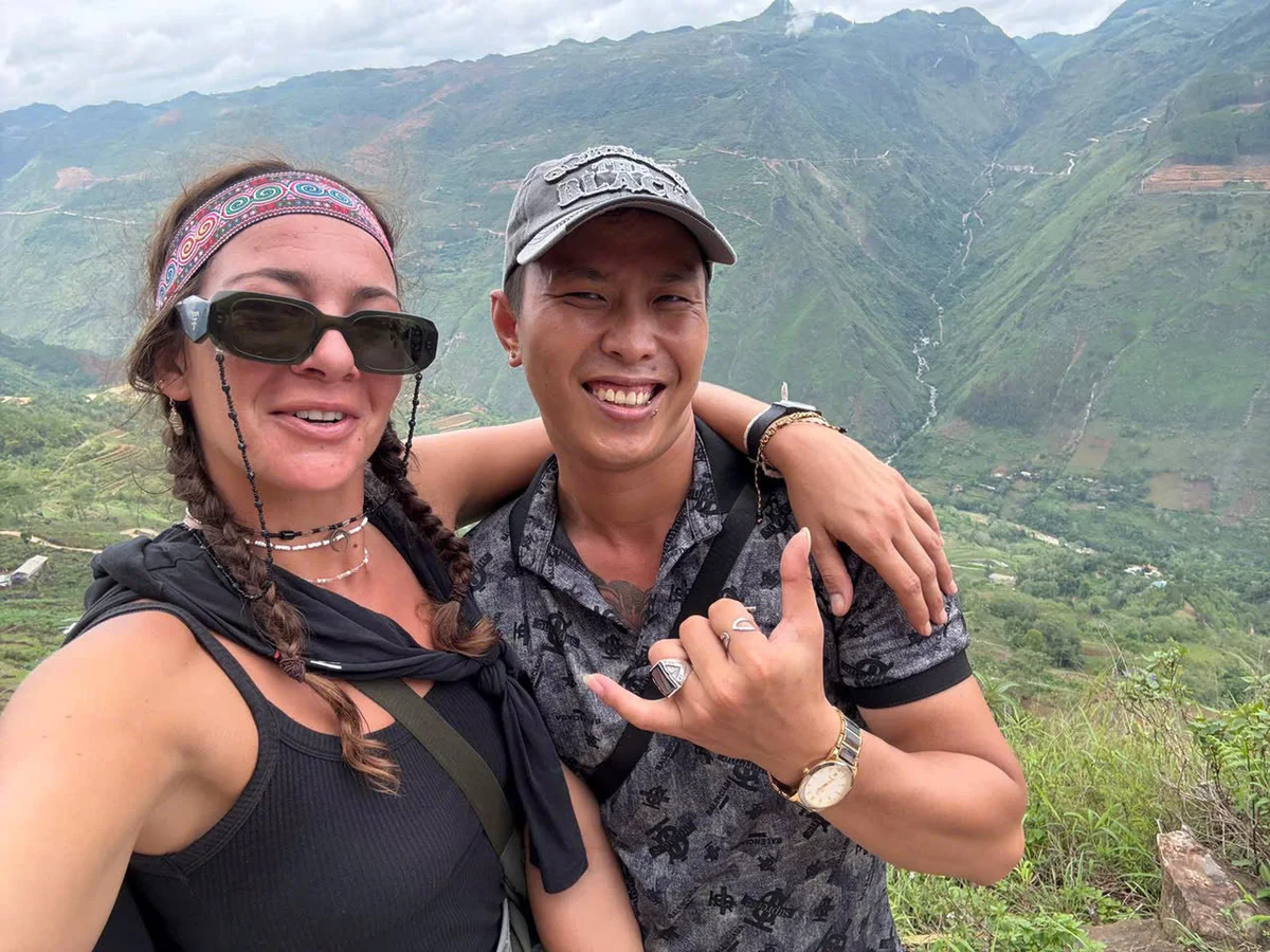Guest and Ha Giang Loop Easy Rider pose in front of local village