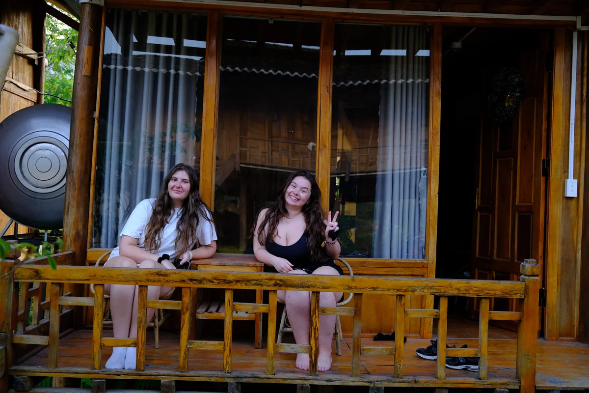 Two girls sit outside their Ha Giang Loop accommodation
