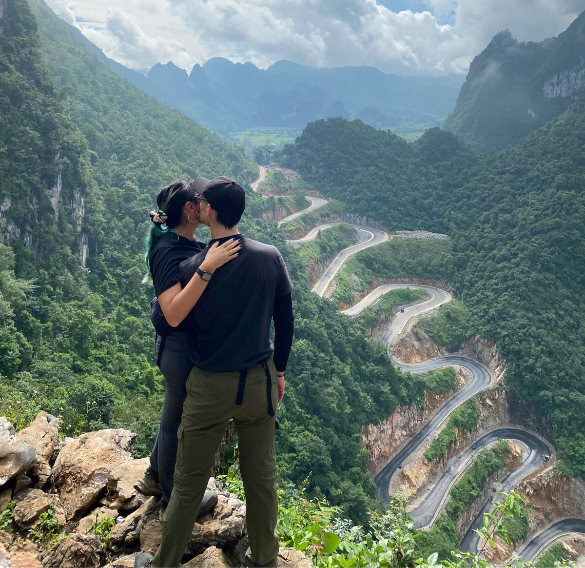 Two guests pose in front of the Me Pia Pass, a 14-story winding road on the way to Cao Bang