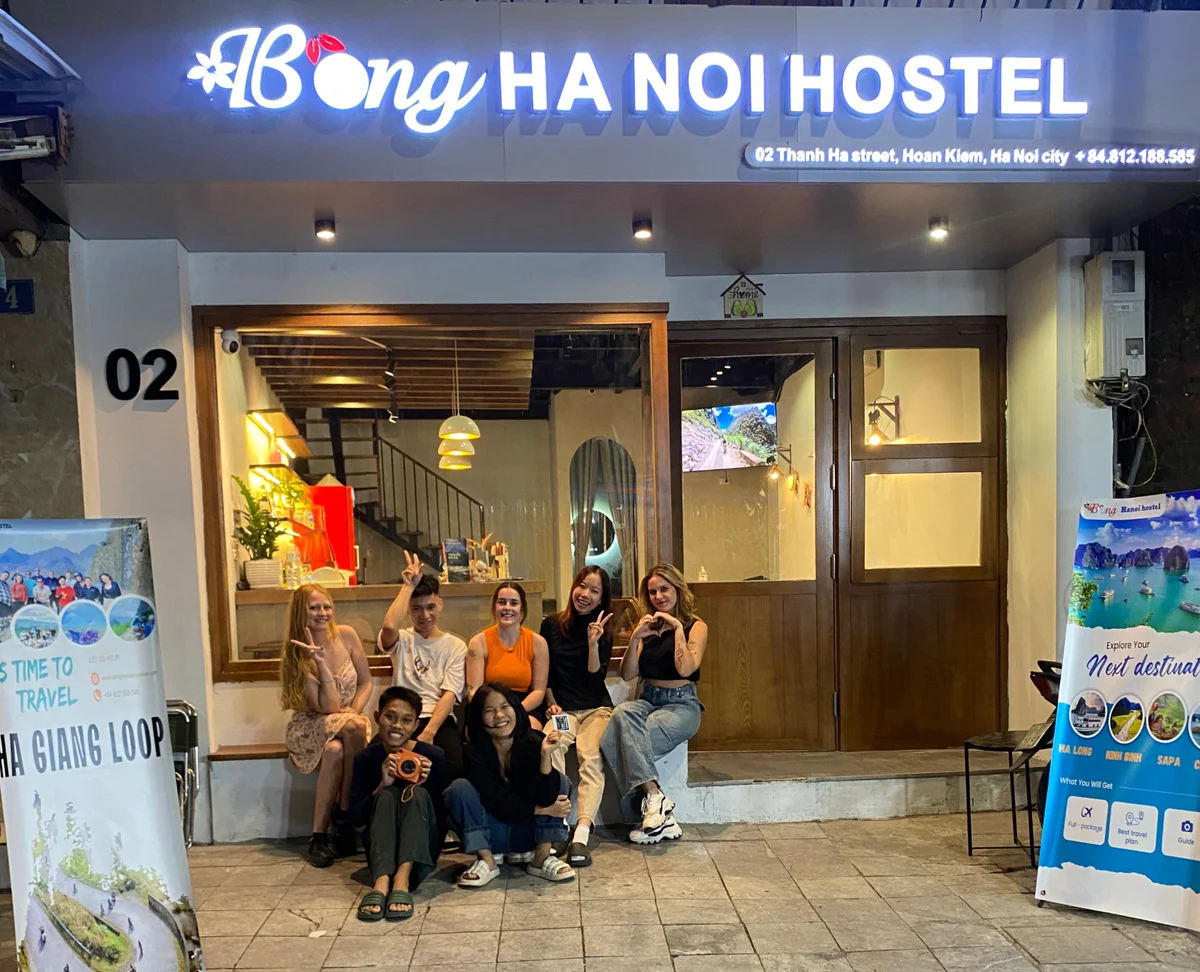Group of smiling people outside bong hanoi hostel in vietnam