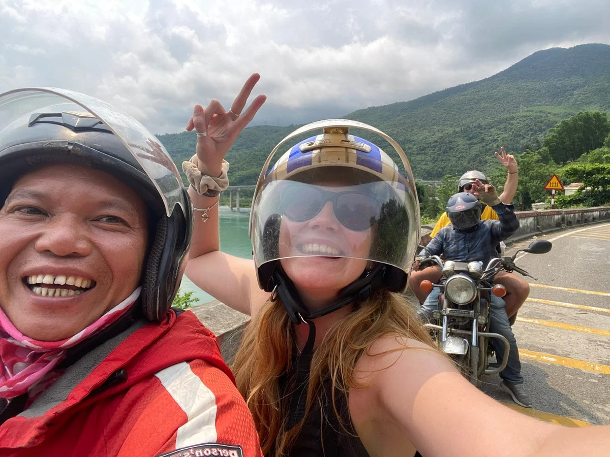 Four people posing on the backs of motorbikes on the Hai Van Pass