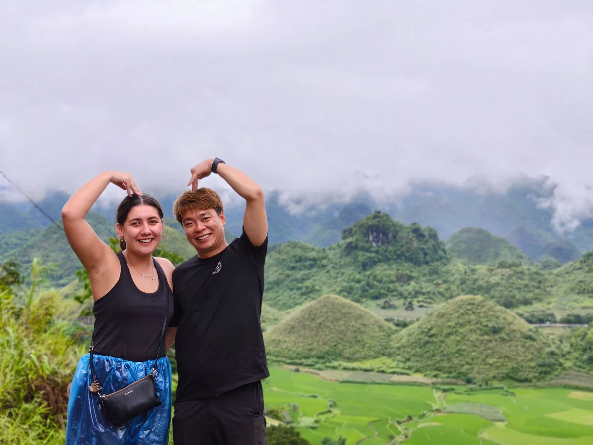 Two people pose in front of two mountains