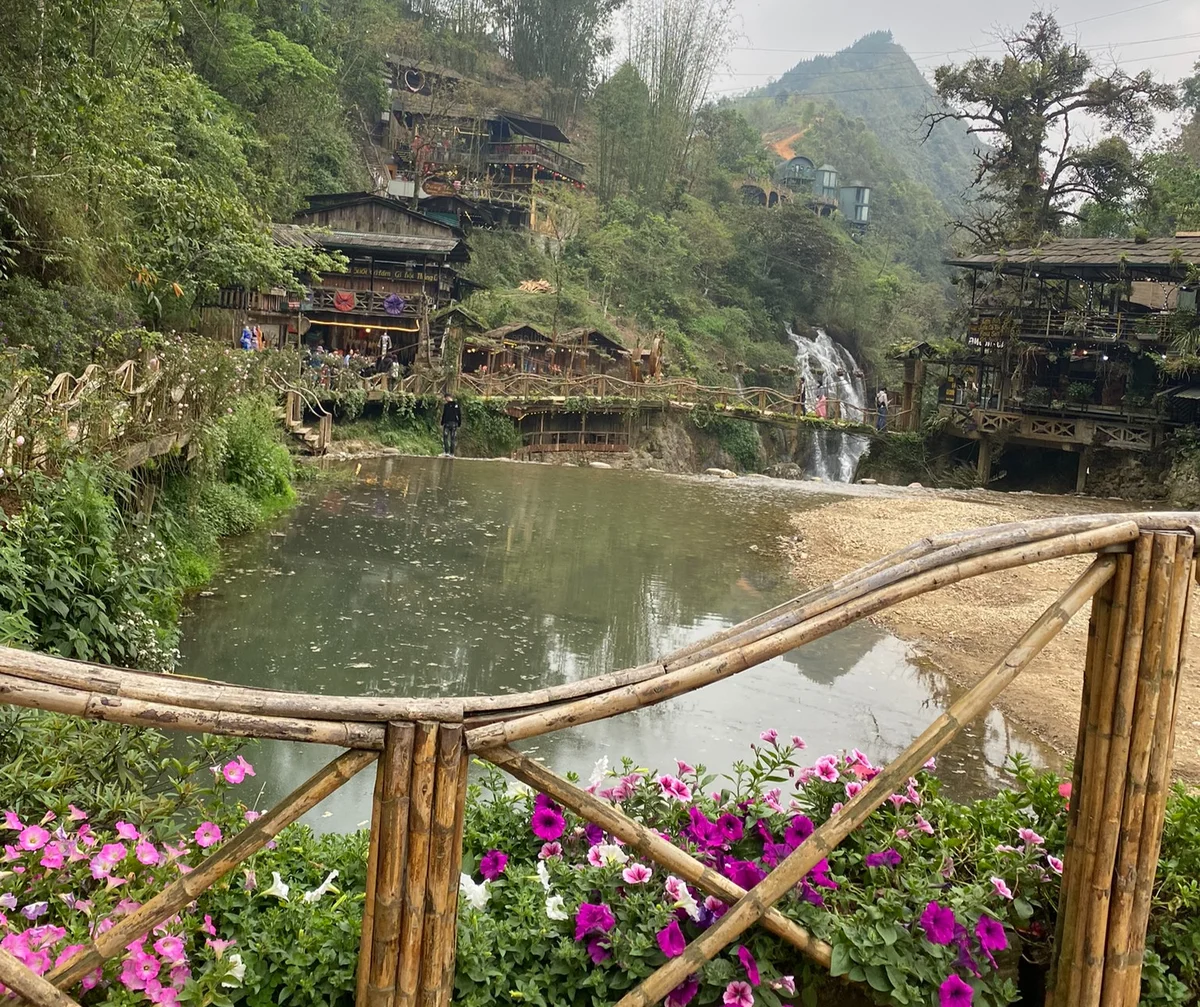 Flowers and wicker bridge over a pond in Cat Cat Village, Sapa
