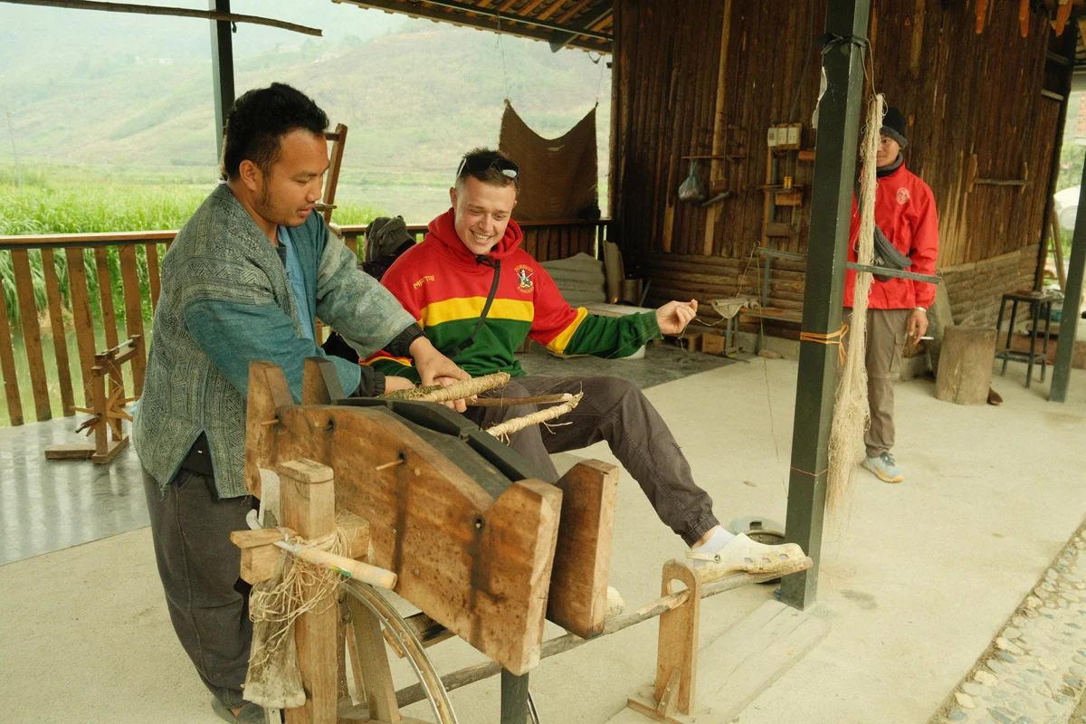 Local man gives a lesson on weaving to a Bong Hostel guest on the Ha Giang Loop