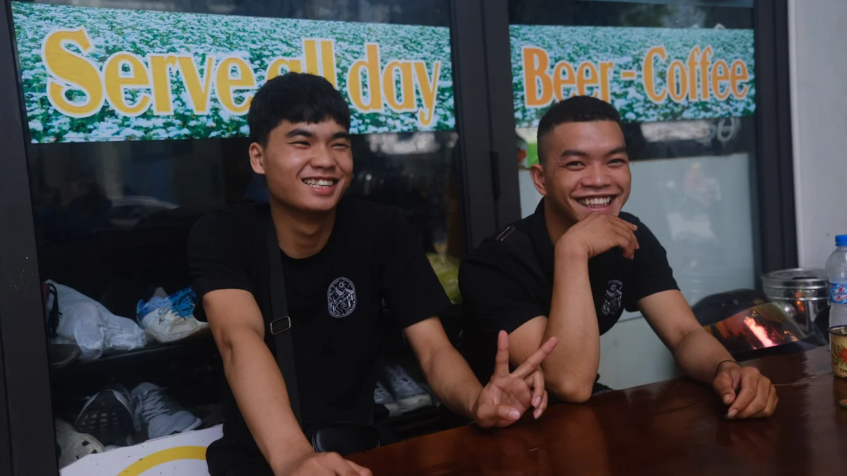 Two men laughing, one is making the peace hand gesture