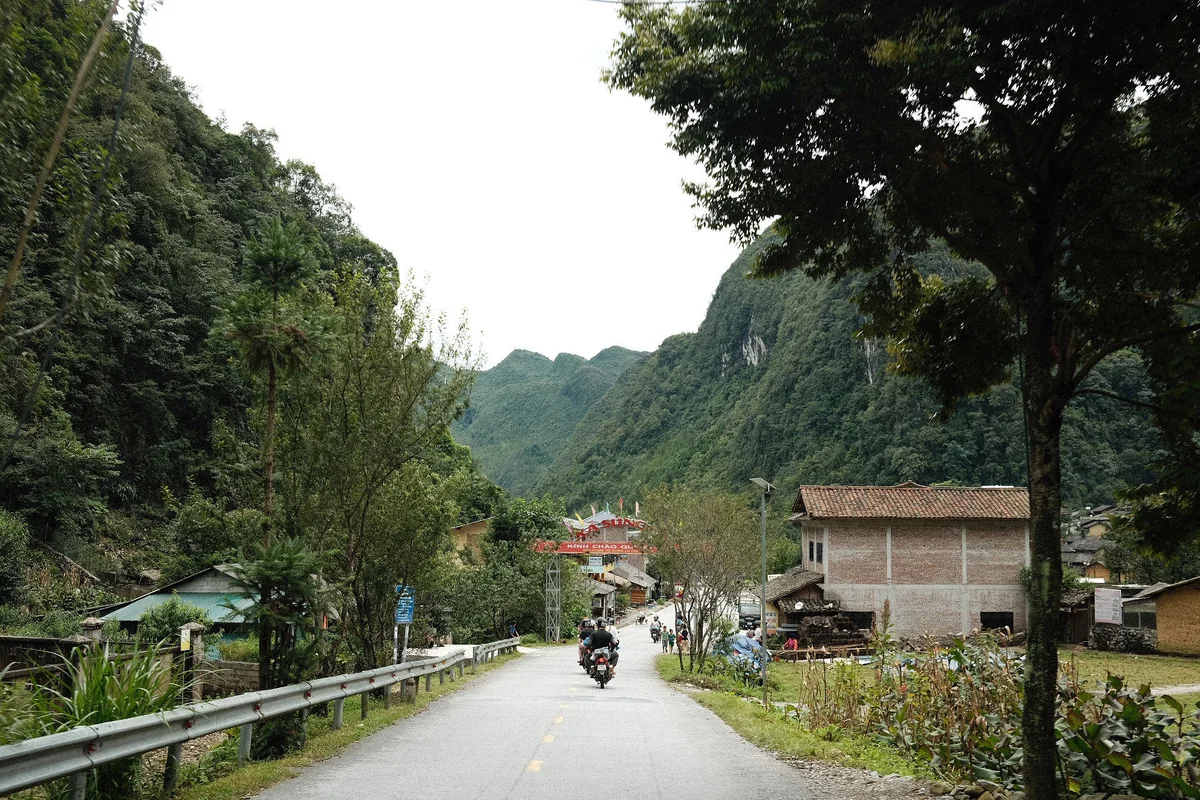 Driving on a road, mountains and small homes either side of the road