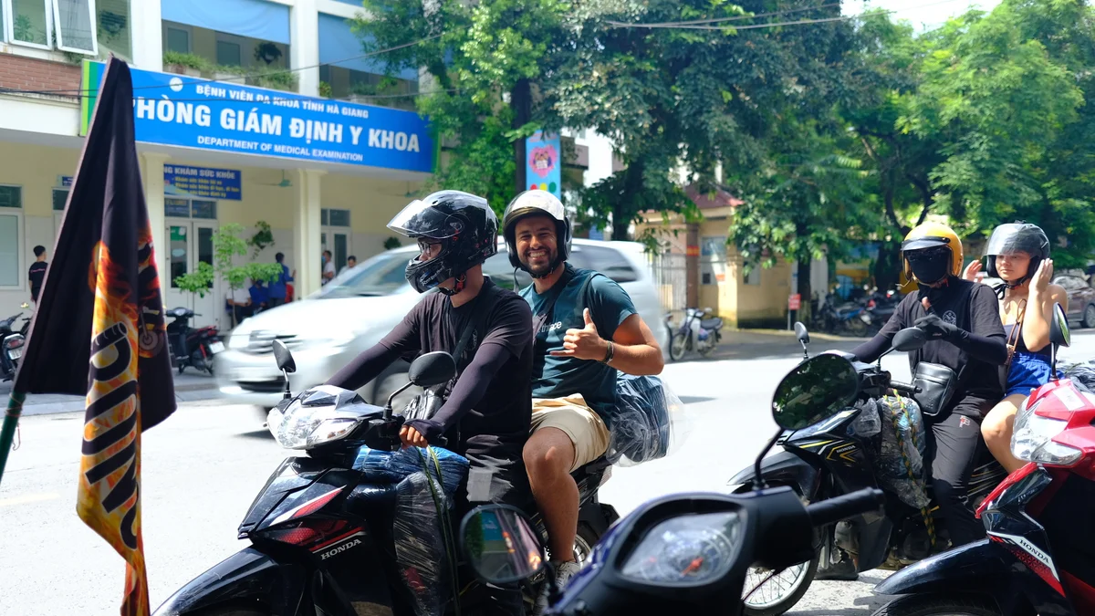 Man makes a thumbs up sign from the back of a motorbike