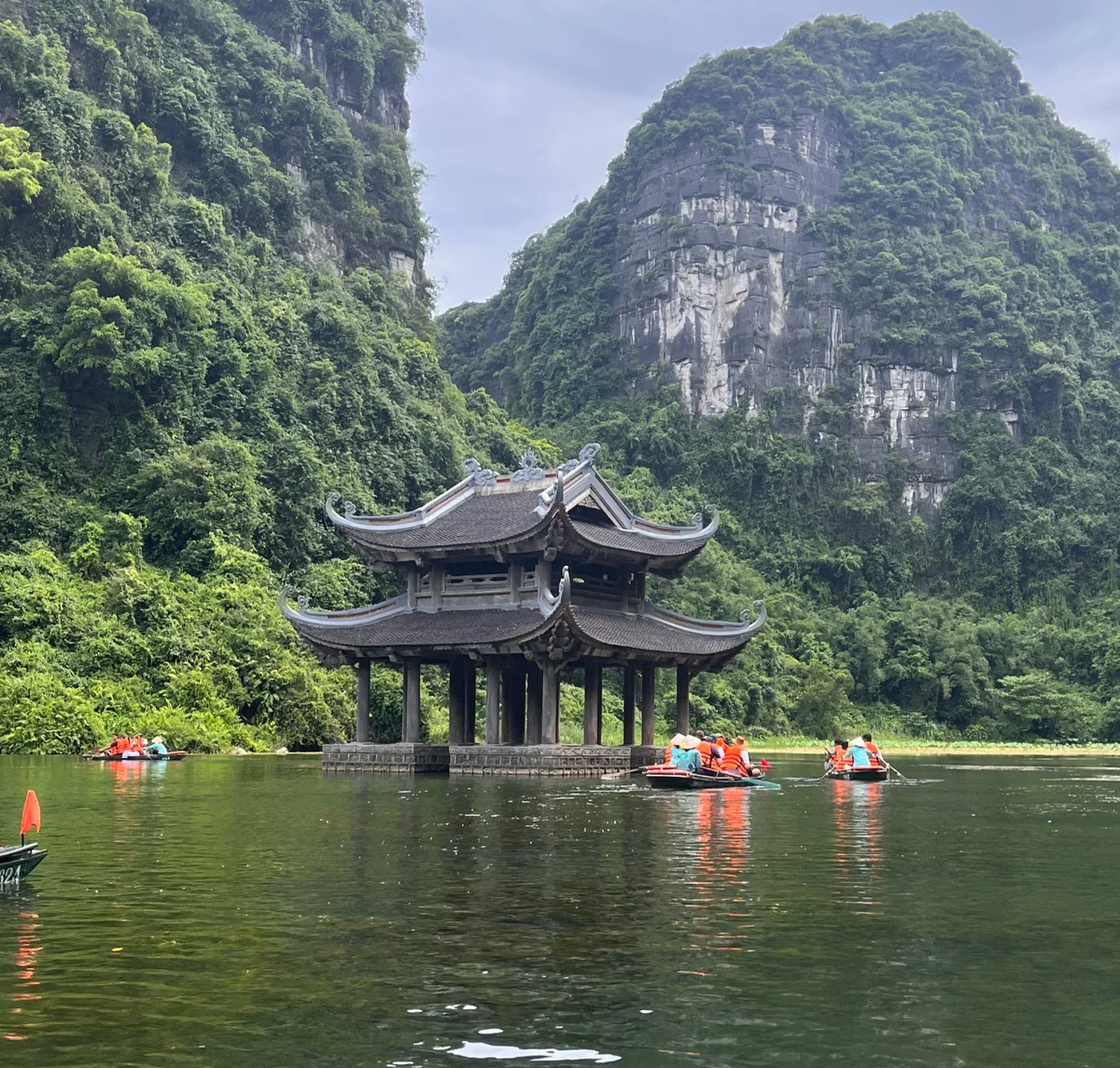 A Pagoda in Ninh Binh, it is on the water and there are rowing boats and passengers all around