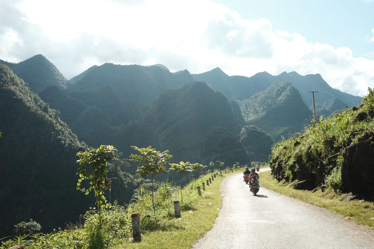 Mountains behind a road with motorbikers on
