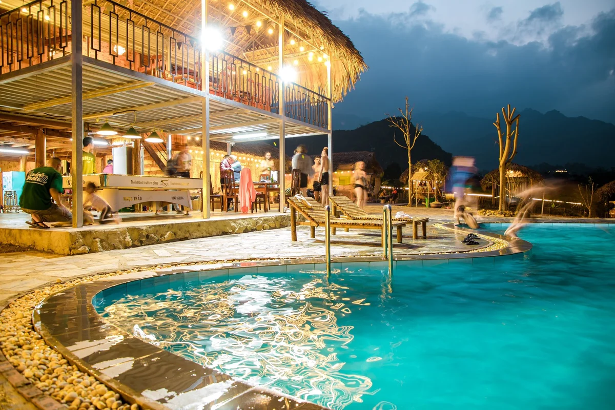 People jumping into a pool next to a homestay