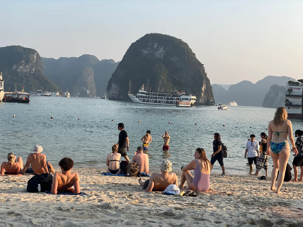People sunbathing on a beach in a lagoon-type bay