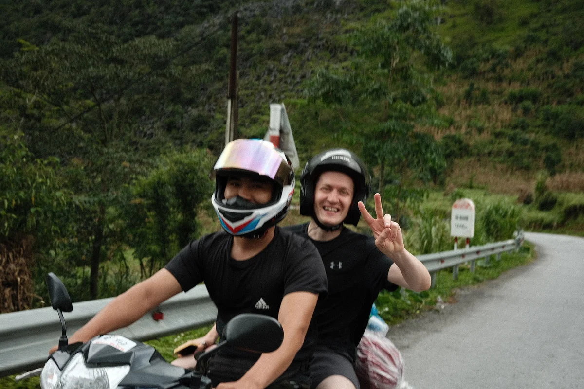Two people smiling on motorbike