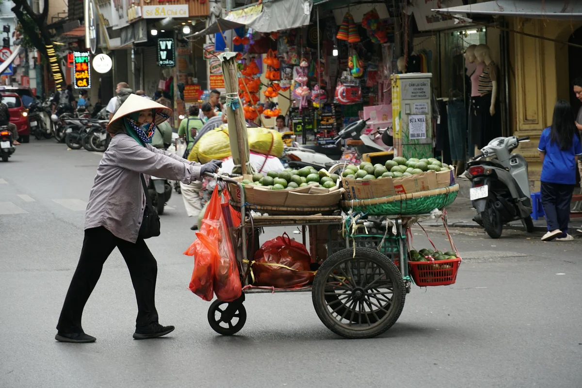 Street vendor in Vietnam pushing a cart through the streets
