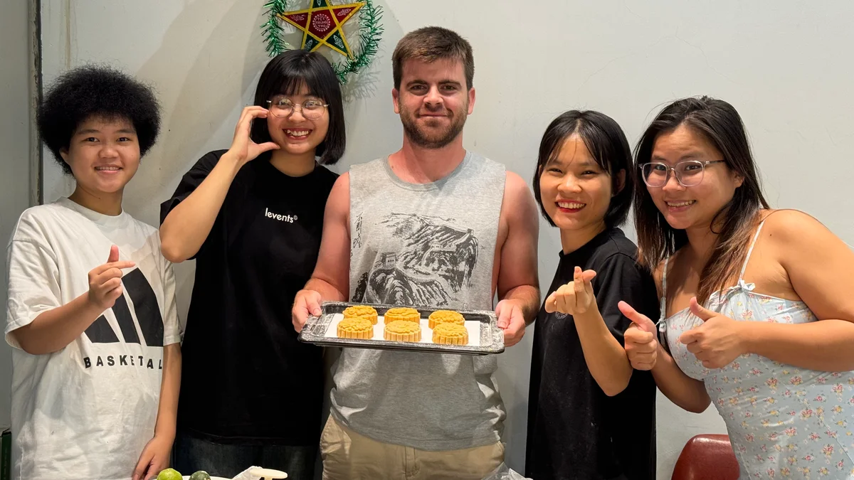 Five people pose for a picture with mooncakes 