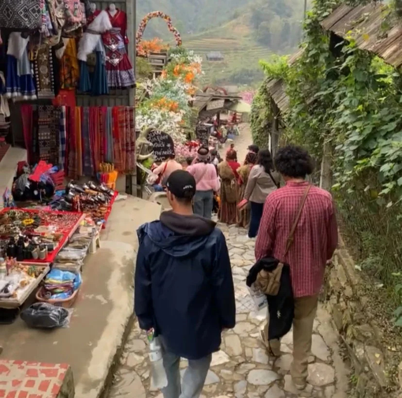 Two men wander through Cat Cat Village in Sapa