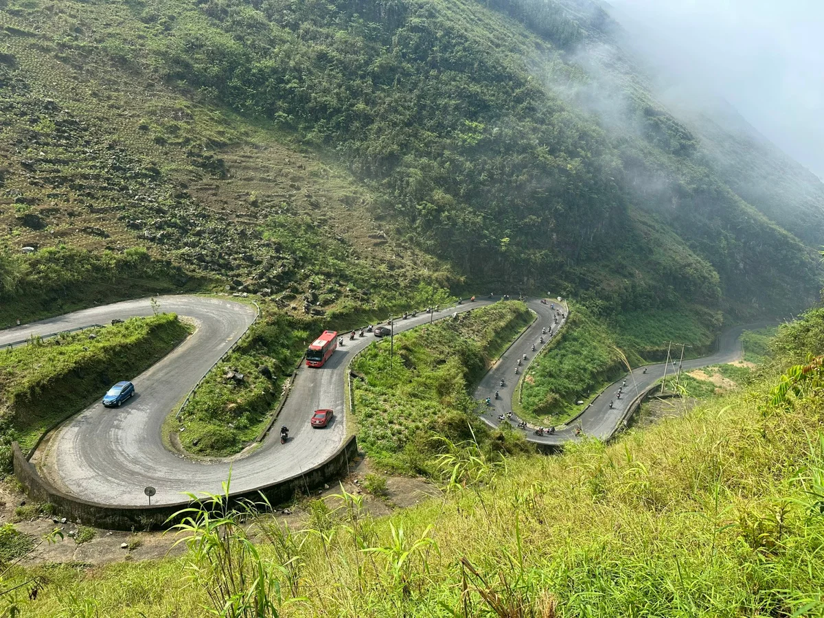Tham Ma Pass in Ha Giang with cars and a bus on the road