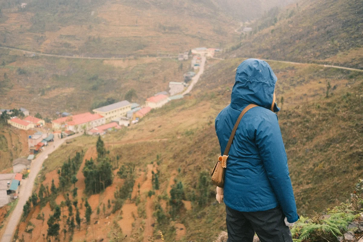 Girl looks out over a town in the valley below on the Ha Giang Loop