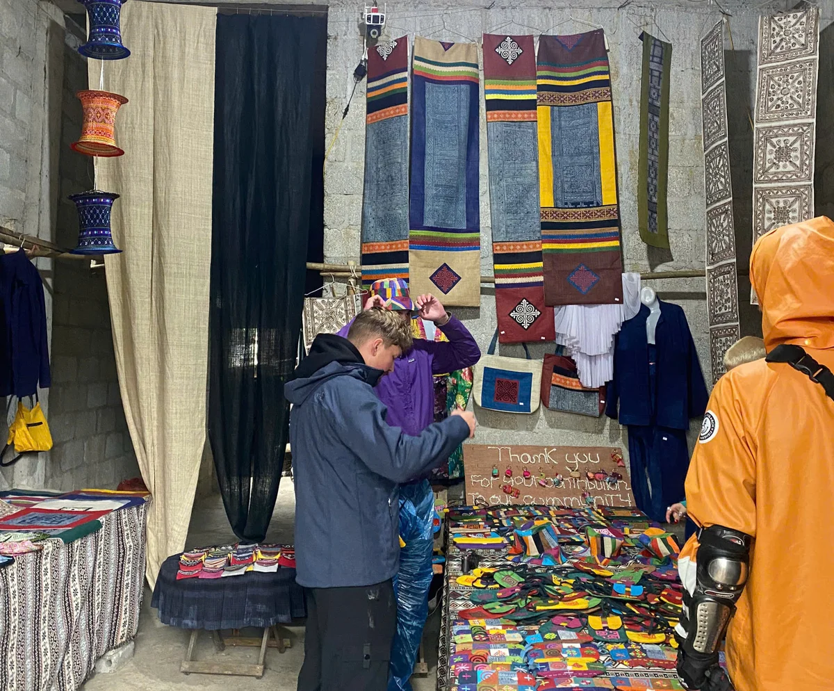 Man is looking at local handmade items in a village market on the Ha Giang Loop