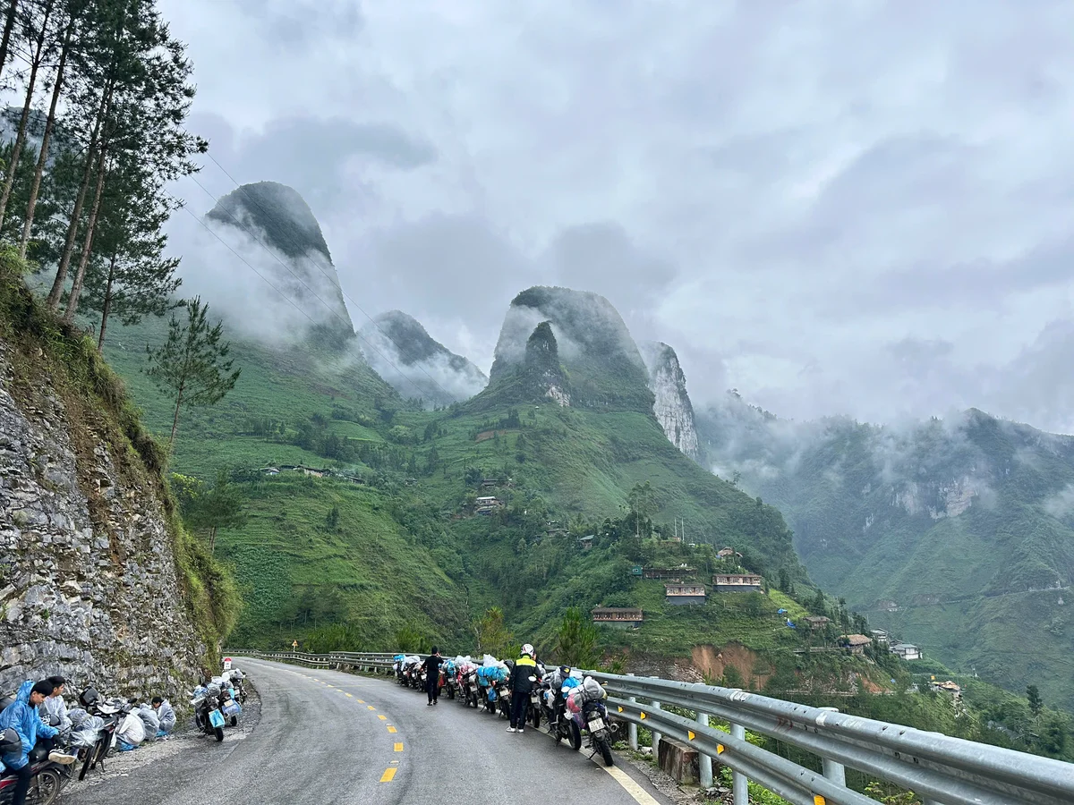Mist hangs over a road with mountains all around