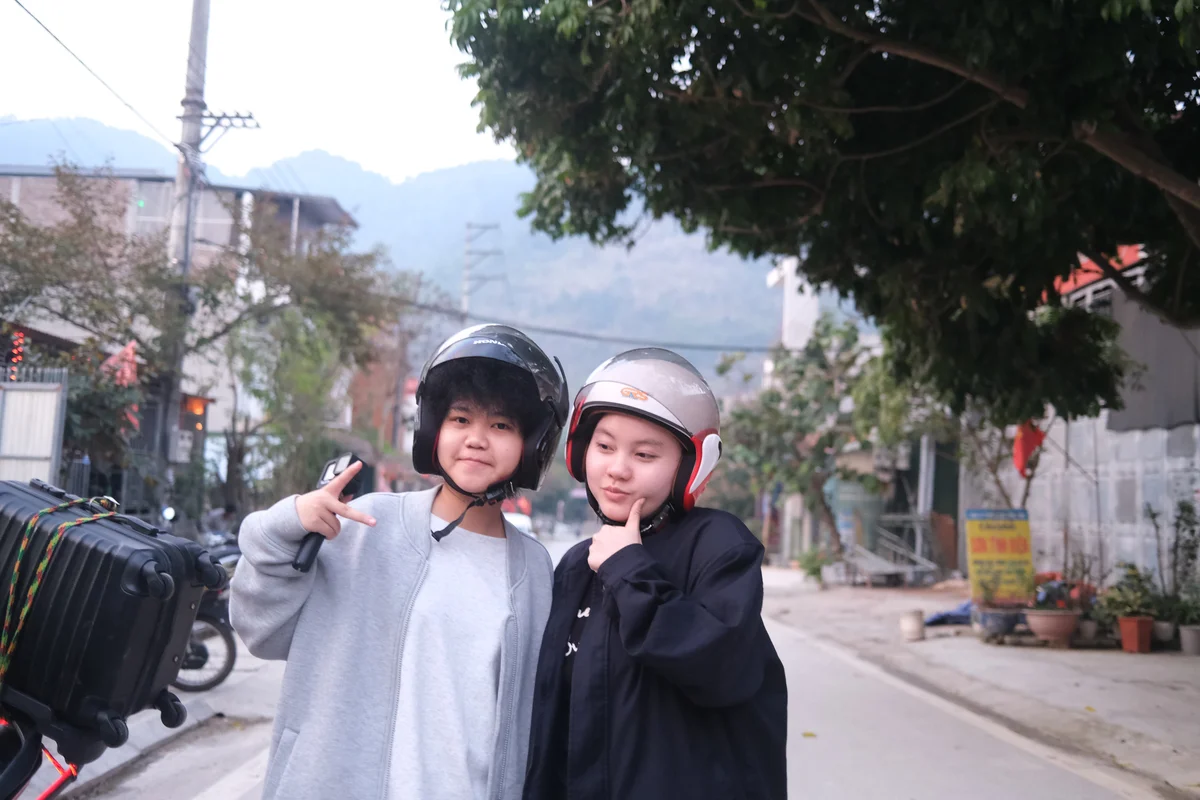 Two people pose for a picture on an empty street