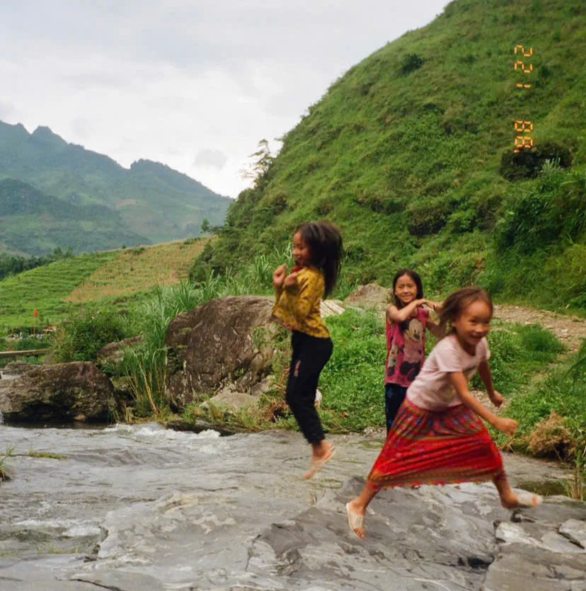 Children playing and jumping for joy in Ha Giang