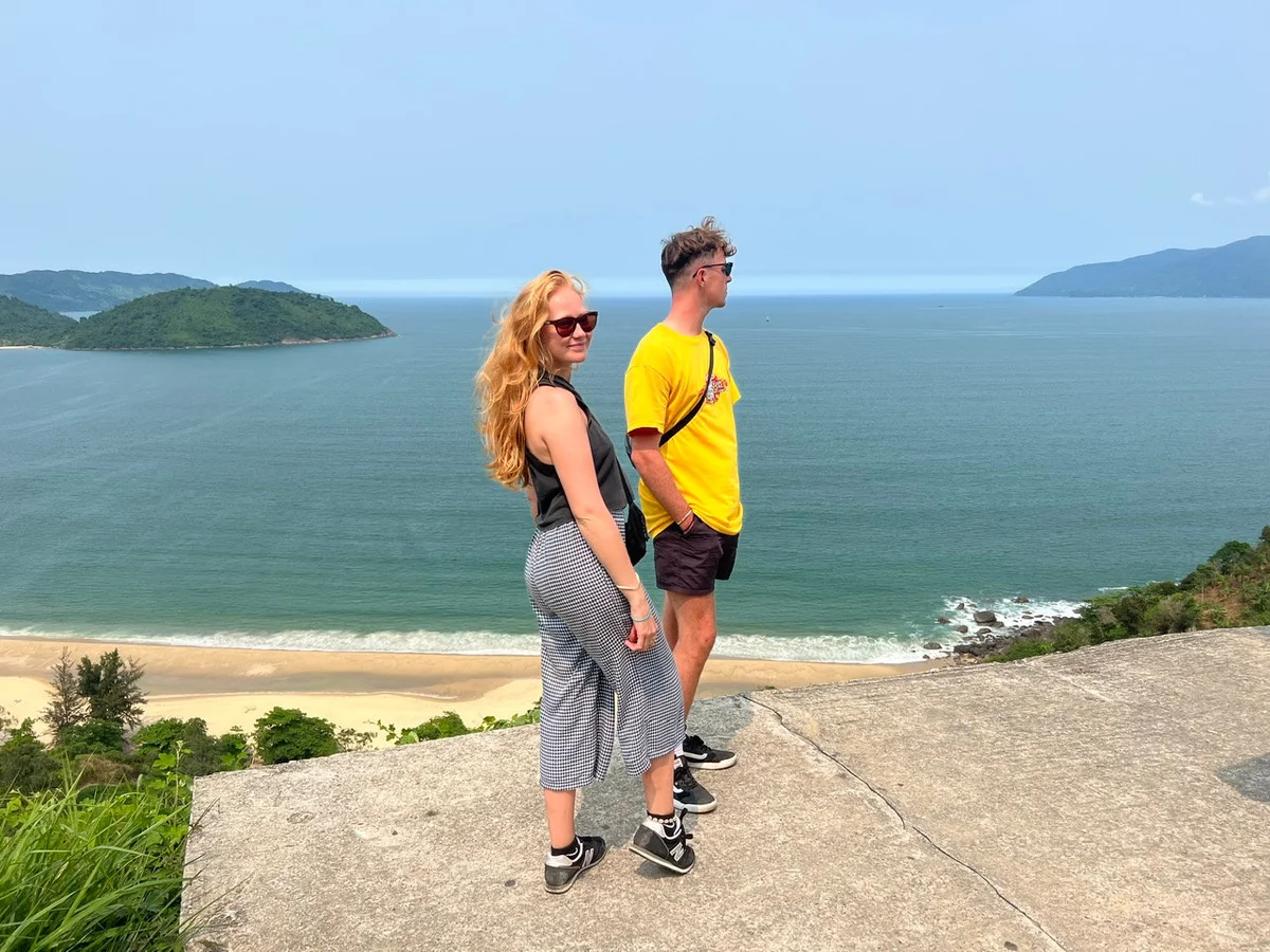 man and woman posing with views of Lang Co beyond