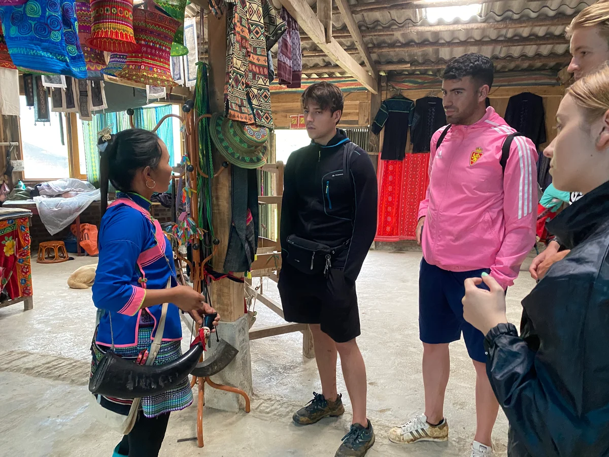 Trekking tourists speak to a local woman about her handicrafts