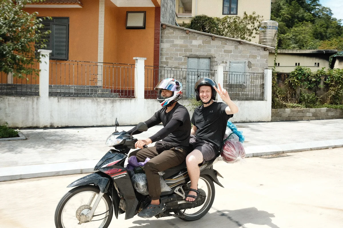 A motorbiker and a passenger smiling