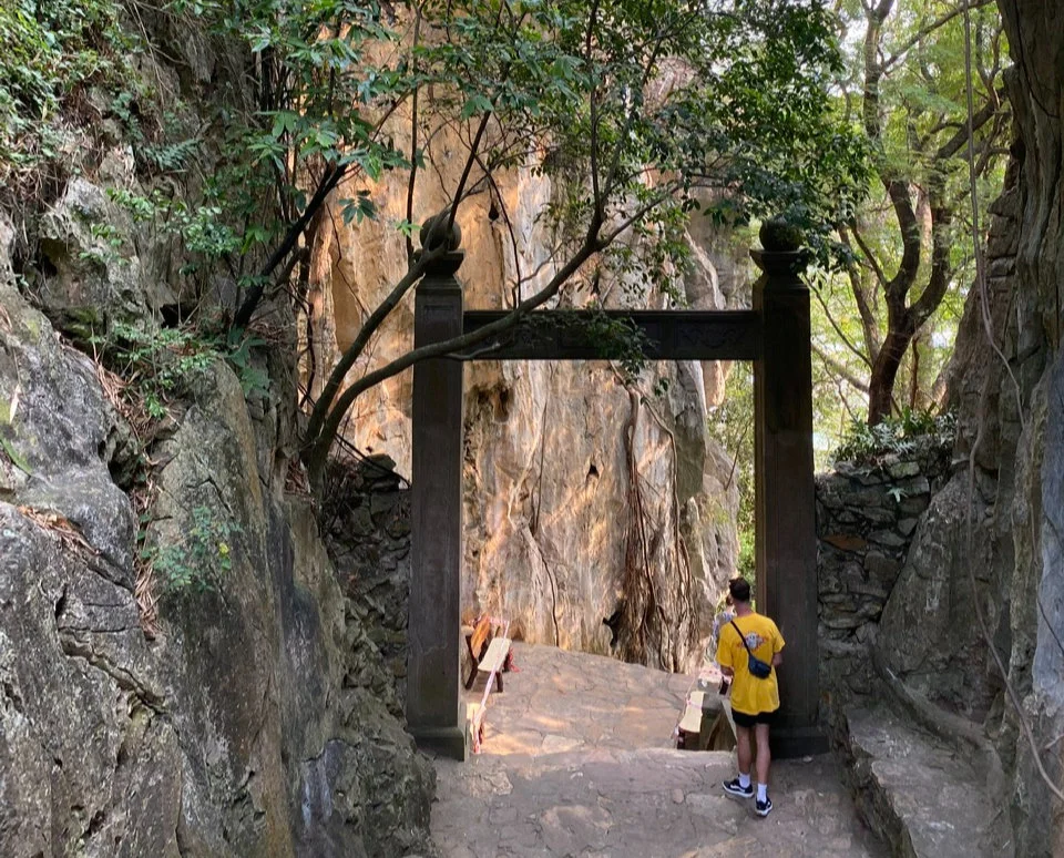 Man looking through a big gateway between mountains