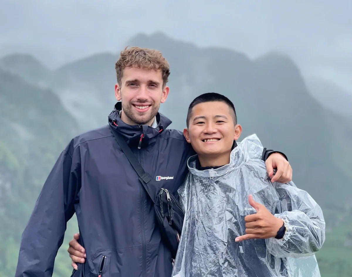 Two people pose in front of the ma pi leng pass