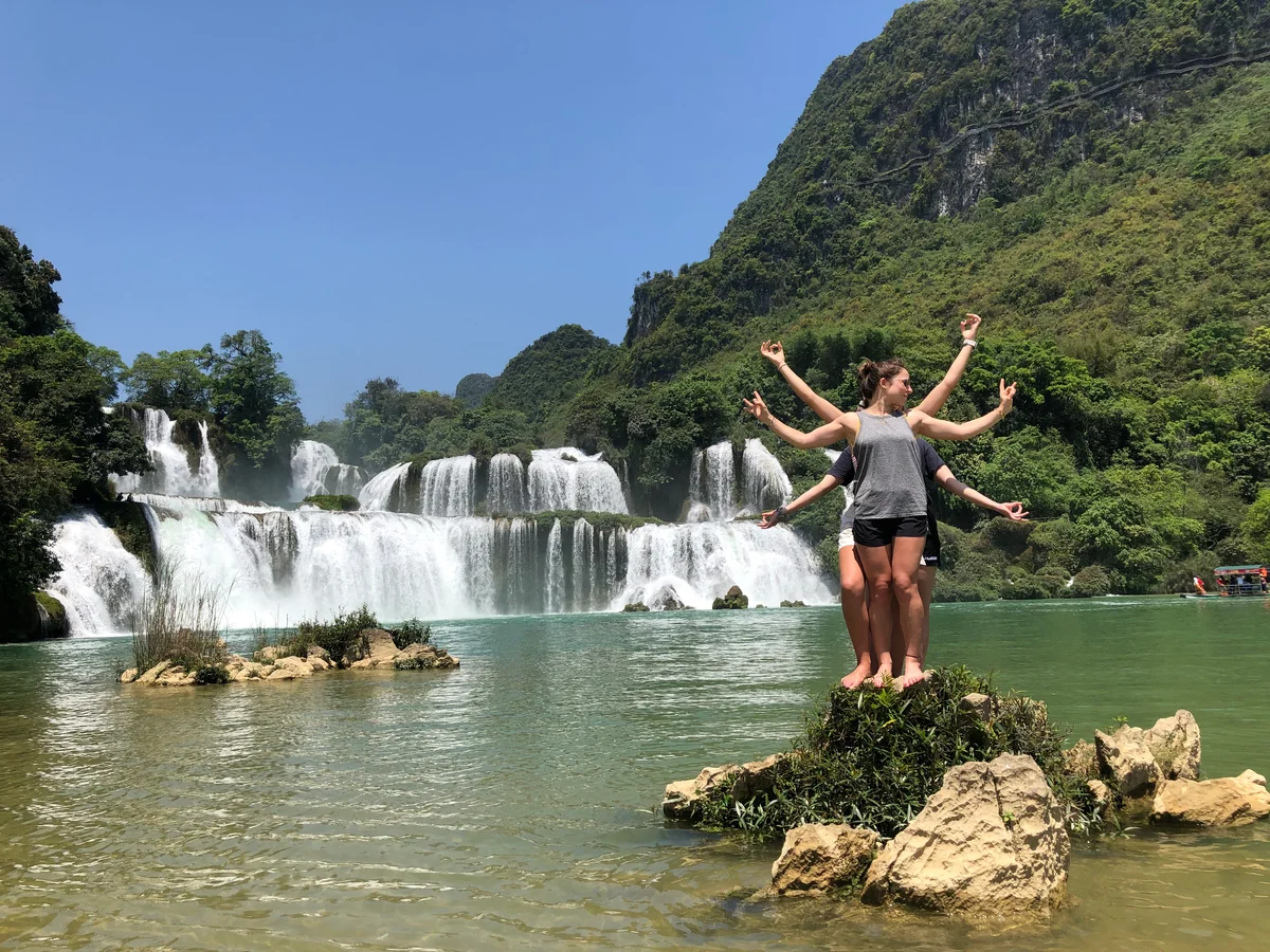 People posing near a large waterfall