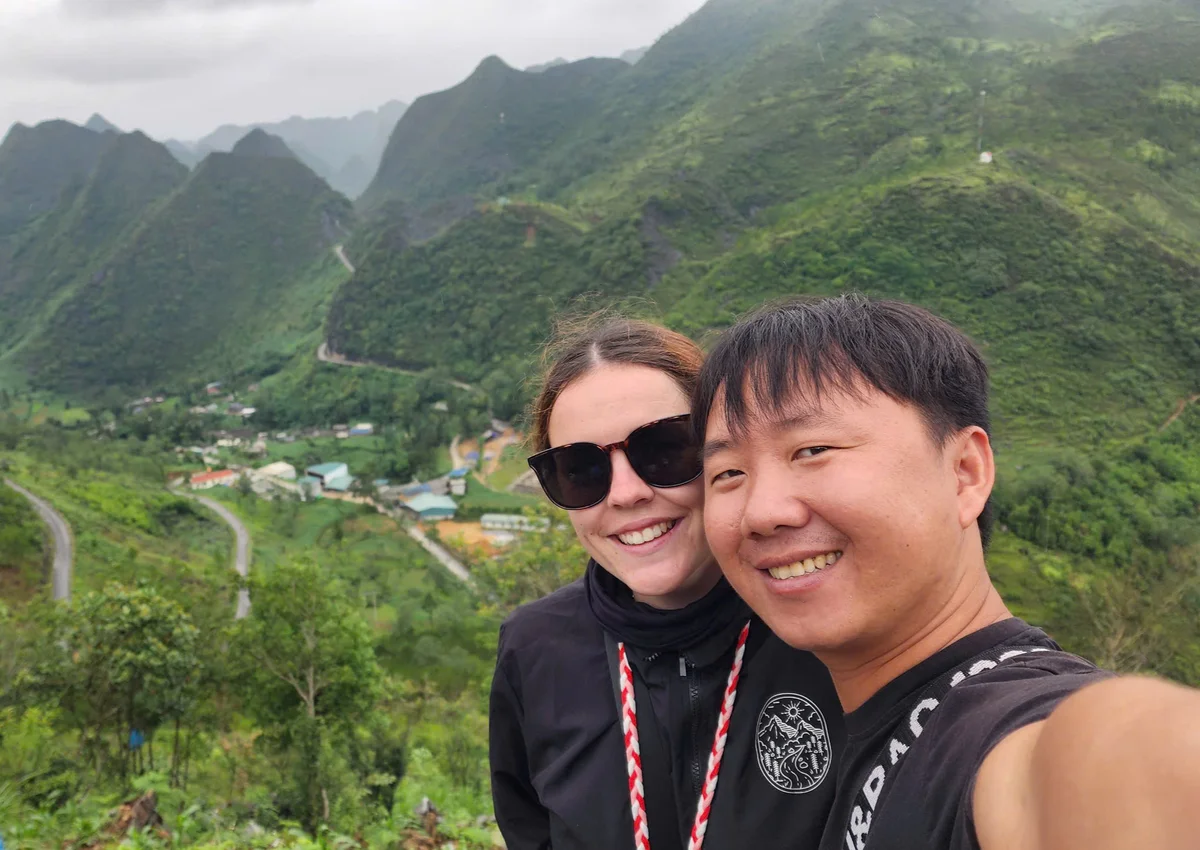 Guest and Ha Giang Loop Easy Rider pose in front of local village