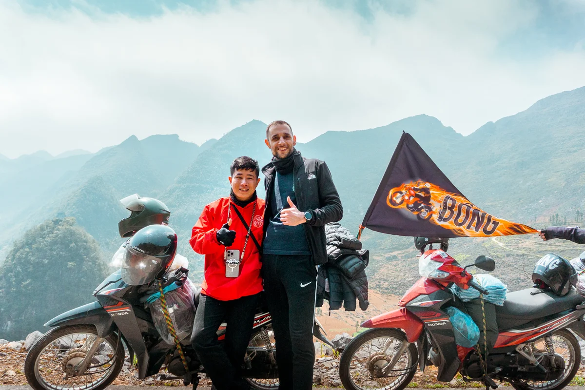 Bong hostel tour guide and guest pose with the Bong bike and flag