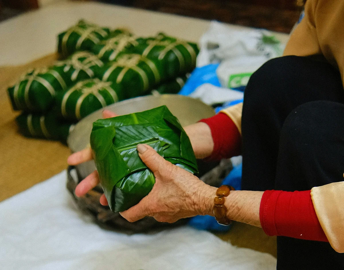 A woman holds a banh chung cake at tet holiday