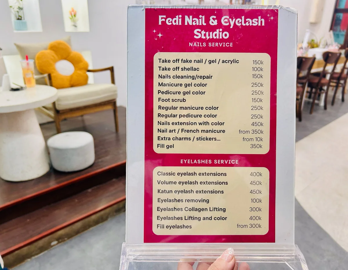 A person holds up a leaflet of nail prices