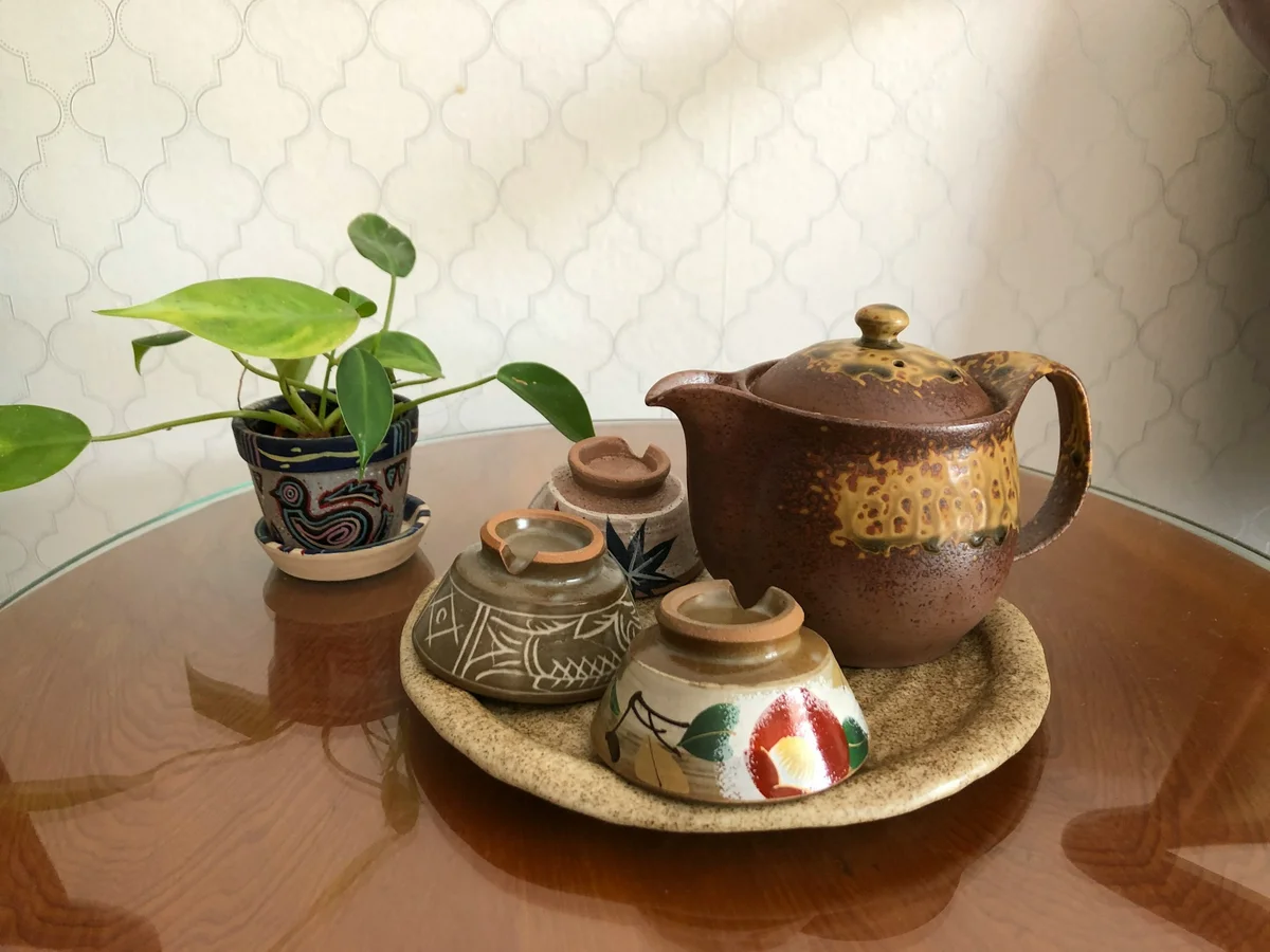 Tea cups and a tea pot on a tray on a table