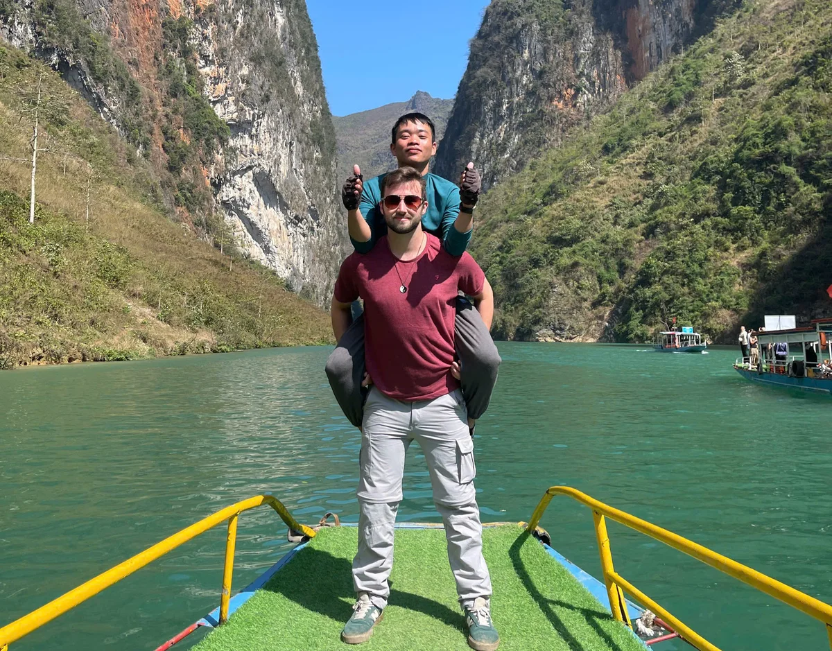 Two men pose at the Nho Que river in Ha Giang