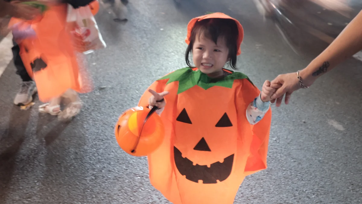 Child dressed as pumpkin poses