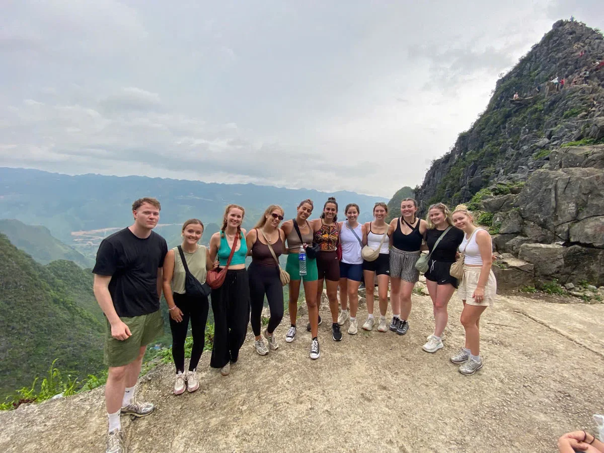 A group of people pose at a viewpoint on the ha giang loop