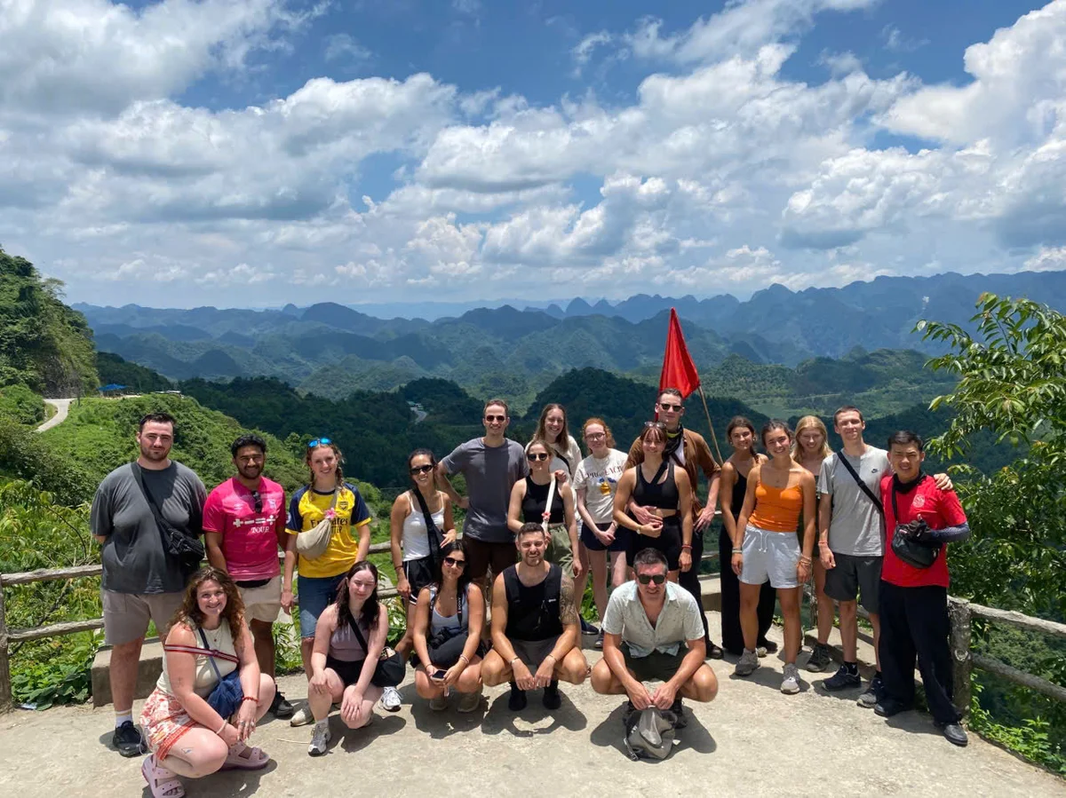A group of people pose for a picture on the Ha Giang Loop with the sun shining
