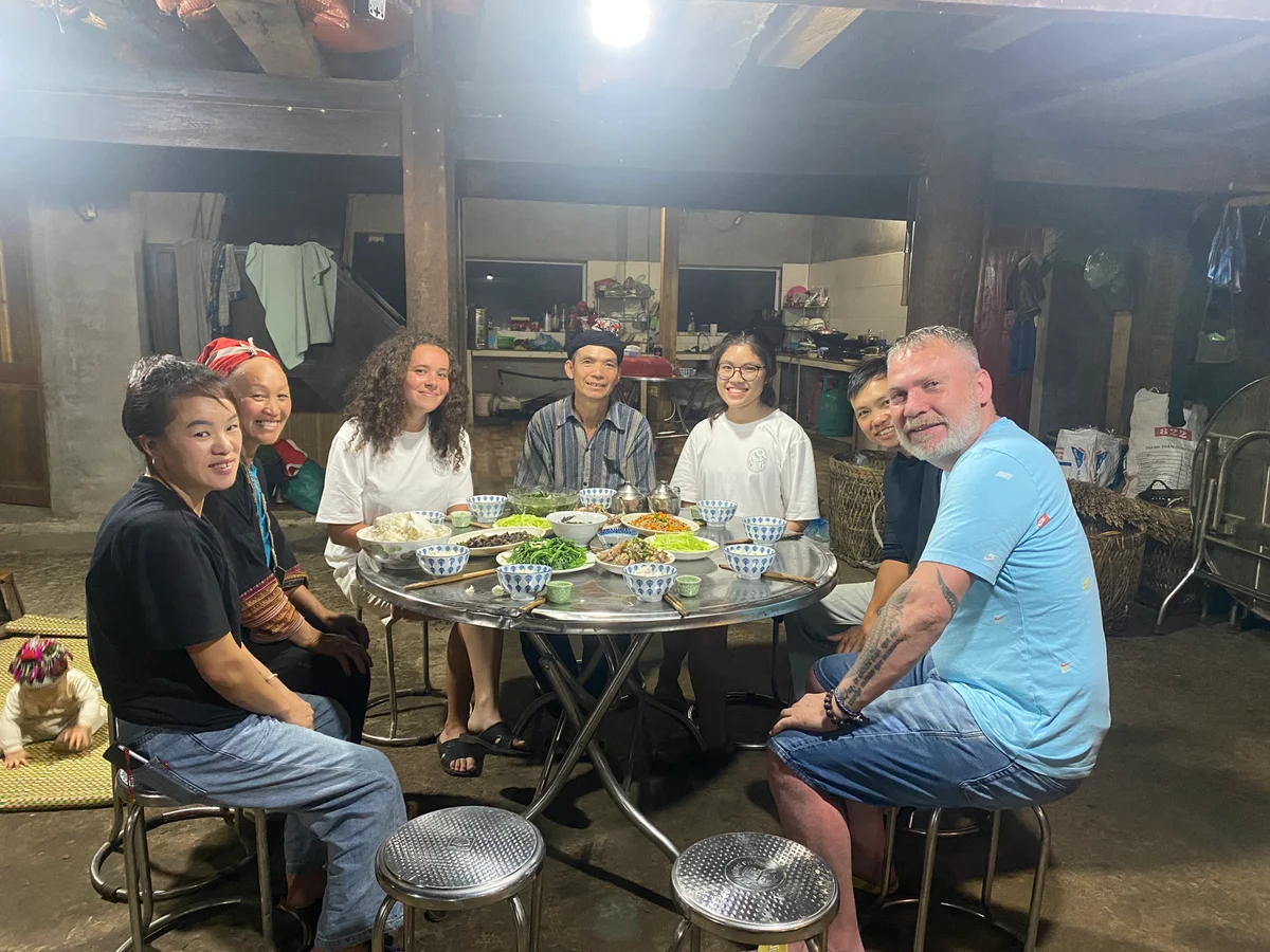 People sit around a table smiling at camera