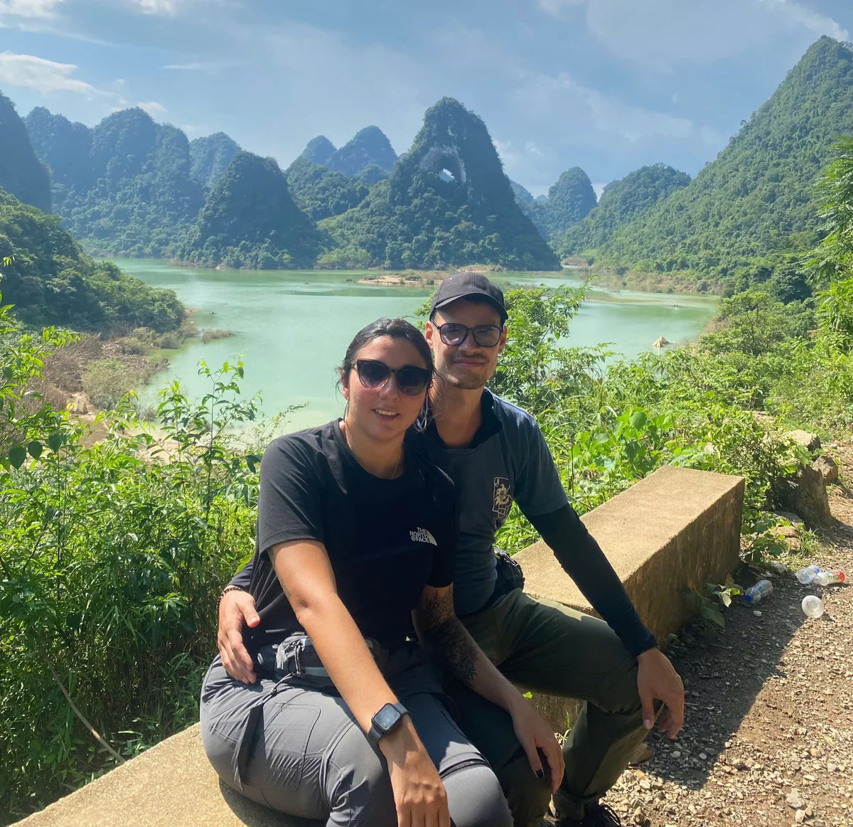 Two people pose in front of a huge blue lake 